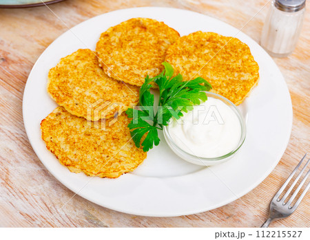 Fried potato pancakes latke are neatly laid out on plate and decorated with parsley leaves. 112215527