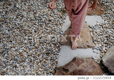 Close up of little girl walking barefoot near the forest cotage,weekend time during summer day. Close up of little girl walking barefoot near the forest cotage,weekend time during summer day. 112215959