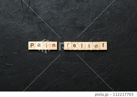 Pain relief word written on wood block. Pain relief text on table, concept. Pain relief word written on wood block. Pain relief text on table, concept. 112217703