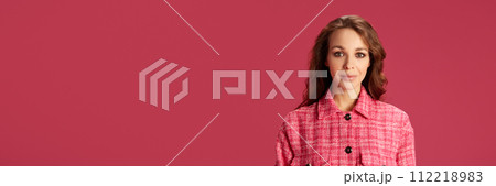 Portrait of attractive young woman with nude makeup, curly brunette hair posing against pink studio background 112218983