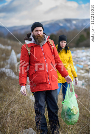 Group of activists picking up litter in nature, environmental pollution, eco activism. and plogging concept. Group of activists picking up litter in nature, environmental pollution, eco activism. and plogging concept. 112219019