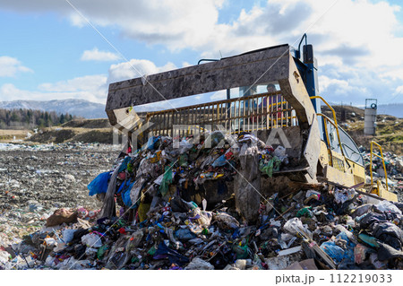 Garbage truck unloading waste on landfill, environmental concept. 112219033