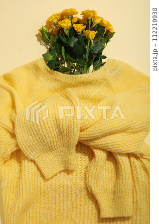 Flowers in yellow sweater on light background, top view Flowers in yellow sweater on light background, top view 112219938