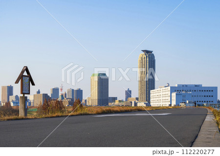 夕陽に染まる荒川土手と川口市街地の風景 112220277