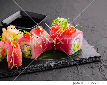 sushi rolls of red tuna on black stone 112220395