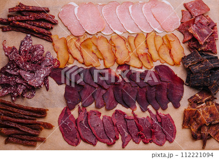 various jerky or dried meats and sausage on a board various jerky or dried meats and sausage on a board 112221094