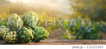 Fresh Artichokes on Wooden Table at Sunset 112221803