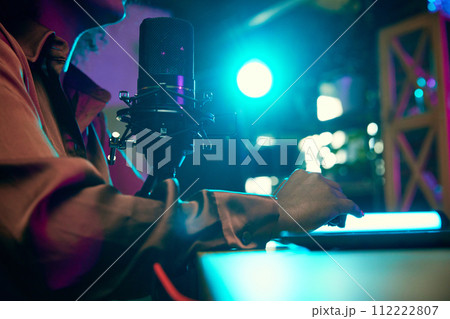 Focus on female hands, microphone and laptop. Blogger making online podcast show, discussing interesting topics Focus on female hands, microphone and laptop. Blogger making online podcast show, discussing interesting topics 112222807