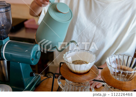 ドリップコーヒーを淹れる女性の手元、カフェで珈琲を淹れる ドリップコーヒーを淹れる女性の手元、カフェで珈琲を淹れる 112226468