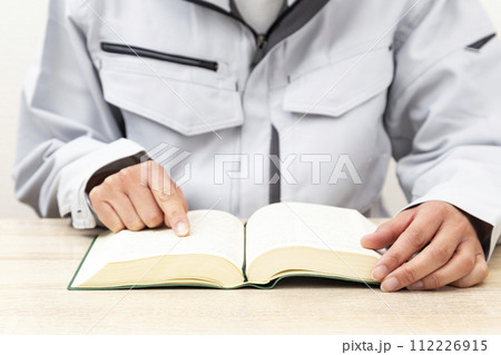 辞書を引く作業服を着た女性 辞書を引く作業服を着た女性 112226915