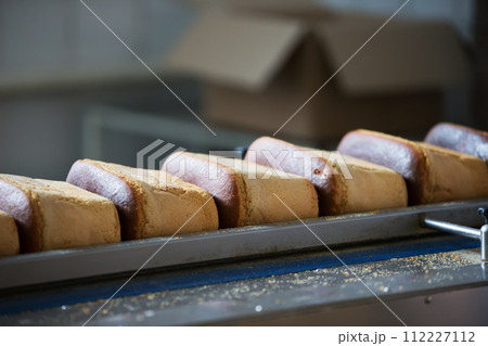 A production line for the production of bread. Bread on a conveyor belt A production line for the production of bread. Bread on a conveyor belt 112227112