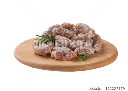 Mini salami on a wooden cutting board isolated. Mini salami on a wooden cutting board isolated. 112227179