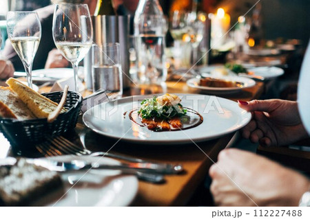 waiter serving salad to couple 112227488