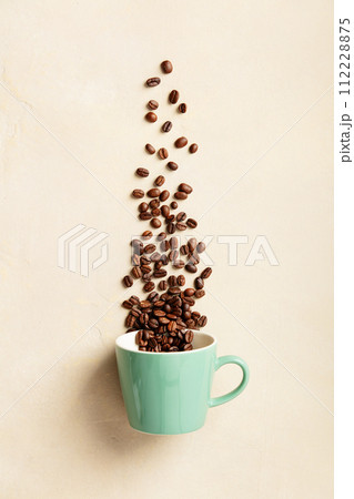 Spilled Coffee Beans from Teal Cup Top View 112228875