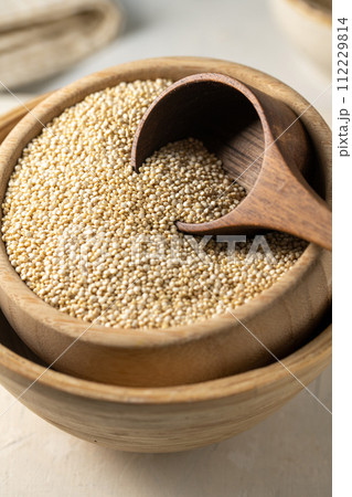 Dry quinoa uncooked in a wooden bowl. Healthy eating Dry quinoa uncooked in a wooden bowl. Healthy eating 112229814