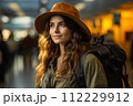 AI-generated content. Travel, happy young woman with backpack and hat, at airport or train station.  112229912