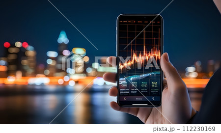 A hand holding a smartphone with a stock market app open. The ba 112230169