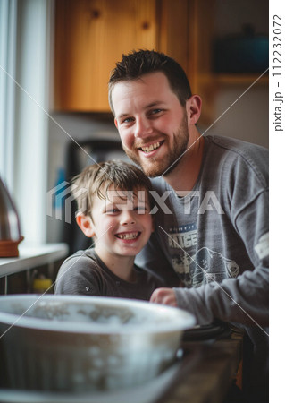 Caucasian father and son washing dishes in the kitchen. Caucasian father and son washing dishes in the kitchen. 112232072