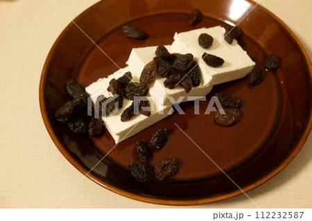 切り分けたクリームチーズにラムレーズンをかけたおやつ 112232587