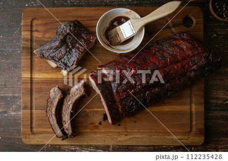 sliced barbeque spare ribs on wooden board 112235428