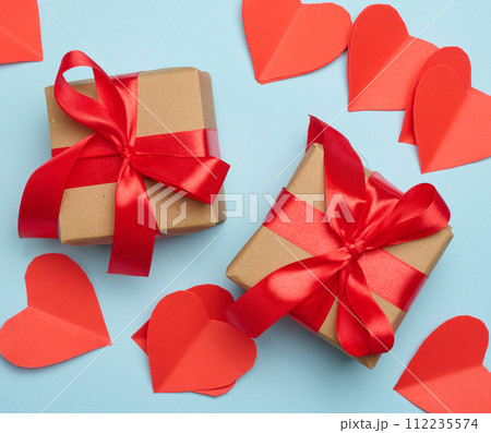 Gift box with red satin ribbon and bow on a blue background.Holiday background 112235574