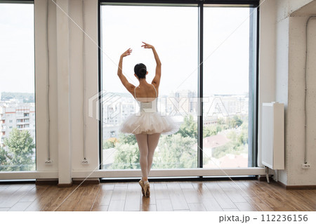 Focused young Caucasian ballerina dressed in white tutu costume. 112236156