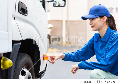 運行前点検を行う女性トラックドライバー 運行前点検を行う女性トラックドライバー 112236329