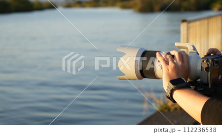 湖を撮影するカメラマン 112236538