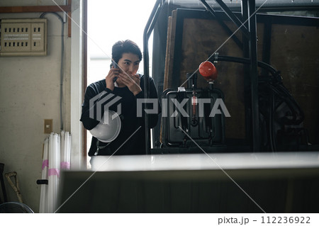 隠れて電話をする解体業者 112236922