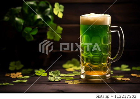 Foamy green beer in a glass mug on wooden table at the background of clover. St. Patrick's Day at the bar, generative ai 112237502