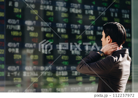 株価が暴落している電光掲示板のリアルタイム株価ボードを見て頭を抱える30代のスーツ姿の男性 株価が暴落している電光掲示板のリアルタイム株価ボードを見て頭を抱える30代のスーツ姿の男性 112237972