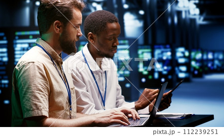System administrators running analysis on servers helping businesses manage databases, host websites and store files. Technicians auditing data center equipment used for high performance computing 112239251