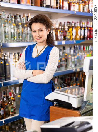 Woman works as salesperson in alcohol department of Russian store. 112240852