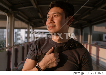 Happy ordinary man walk on the sky-train platform in Bangkok. 112241024