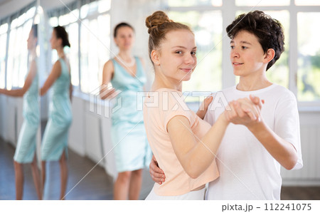 Girl and a boy are having fun learning to dance tango at choreographic school Girl and a boy are having fun learning to dance tango at choreographic school 112241075