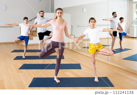 Family practicing yoga in pairs at gym Family practicing yoga in pairs at gym 112241138