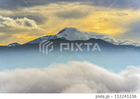 Cloud bank and sunrise on the Cayambe volcano seen from Quito capital of Ecuador 112241236