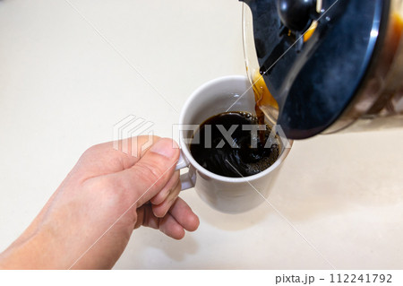 マグカップにコーヒーを注ぐ マグカップにコーヒーを注ぐ 112241792