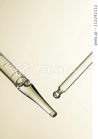 Clear liquid droplets falling from a dropper that can be used for cosmetic and medical images. 112242112