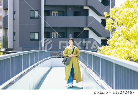 歩道橋を歩く女性 112242467