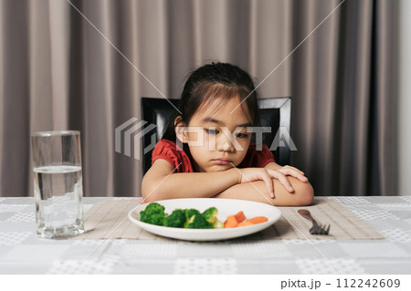 Little cute kid girl refusing to eat healthy vegetables. Children do not like to eat vegetables. Little cute kid girl refusing to eat healthy vegetables. Children do not like to eat vegetables. 112242609