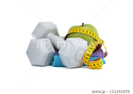 Two gray dumbbells and green apple with tape measure Two gray dumbbells and green apple with tape measure 112242876