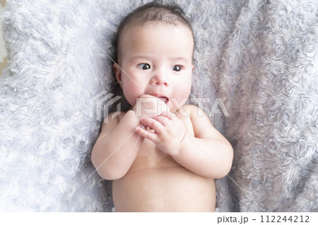 ふかふかのベッドの上で指しゃぶりをしているハーフの裸の男の子赤ちゃん ふかふかのベッドの上で指しゃぶりをしているハーフの裸の男の子赤ちゃん 112244212