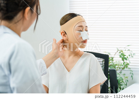 美容外科で整形手術を受けて術後に医師の診察を受ける女性(ダウンタイム・小顔整形・エラ削り・骨切り) 美容外科で整形手術を受けて術後に医師の診察を受ける女性(ダウンタイム・小顔整形・エラ削り・骨切り) 112244459