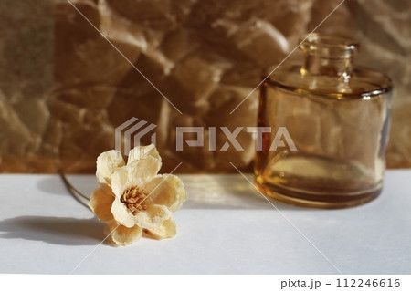 ベージュ色の一輪のドライフラワーと茶色の小さな花瓶 112246616