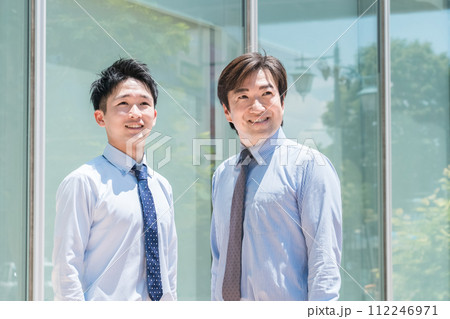 オフィスビルの前にいる男性ビジネスマン(上司・部下・チーム・先輩・後輩) オフィスビルの前にいる男性ビジネスマン(上司・部下・チーム・先輩・後輩) 112246971