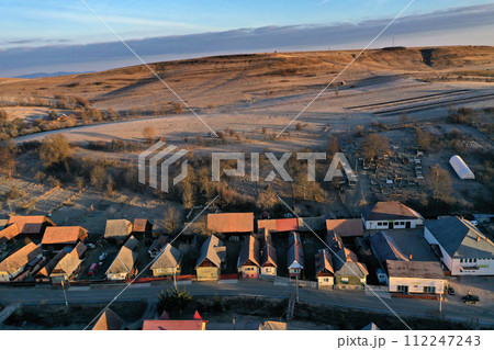 Aerial view of residential houses in a village during morning sunrise lights Aerial view of residential houses in a village during morning sunrise lights 112247243