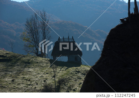 Autumn countryside landscape with wooden houses, thatched roof Autumn countryside landscape with wooden houses, thatched roof 112247245