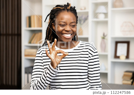 Happy Woman Gesturing Ok Sign at Home Happy Woman Gesturing Ok Sign at Home 112247586
