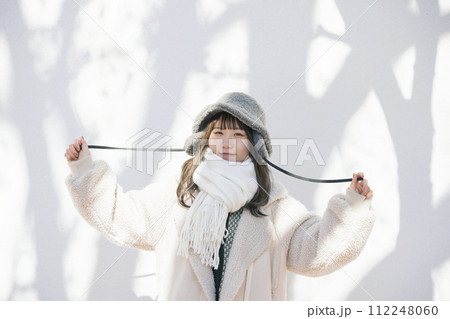 木の影と一緒に立つ冬の服装をした若い女性 木の影と一緒に立つ冬の服装をした若い女性 112248060